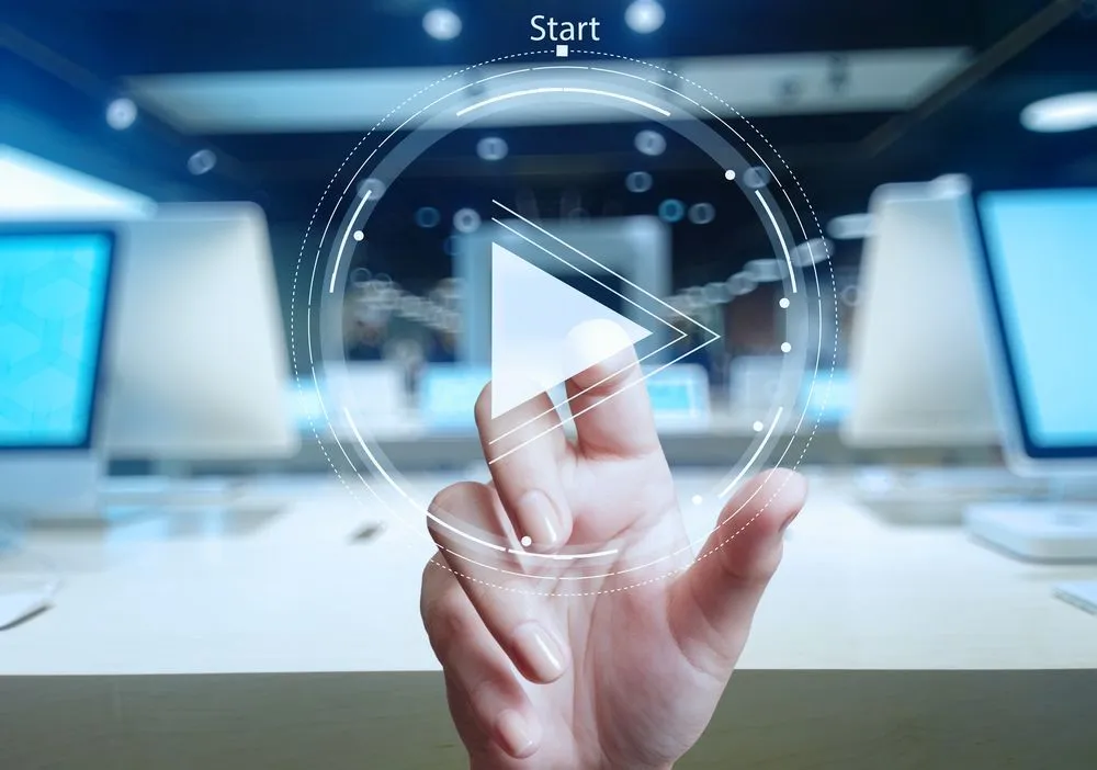 Hand press play button on a touch screen