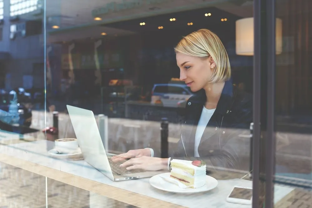 View through window of a young female student searching needed for learning information with