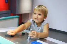 Youngster operating controls in a mockup cargo loading exhibit at the Miami Children's Museum on Watson Island