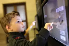 Child using interactive touch screen in a museum